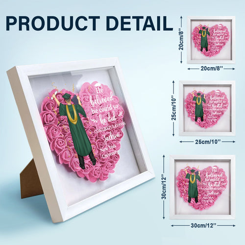 Heart-shaped graduation gift flower shadow box with pink flowers and white frame.